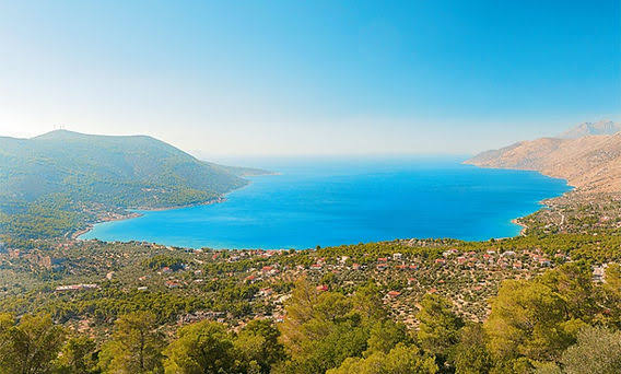 Aerial panoramic view of the Porto Germeno bay, surrounded by pine forest and mountains