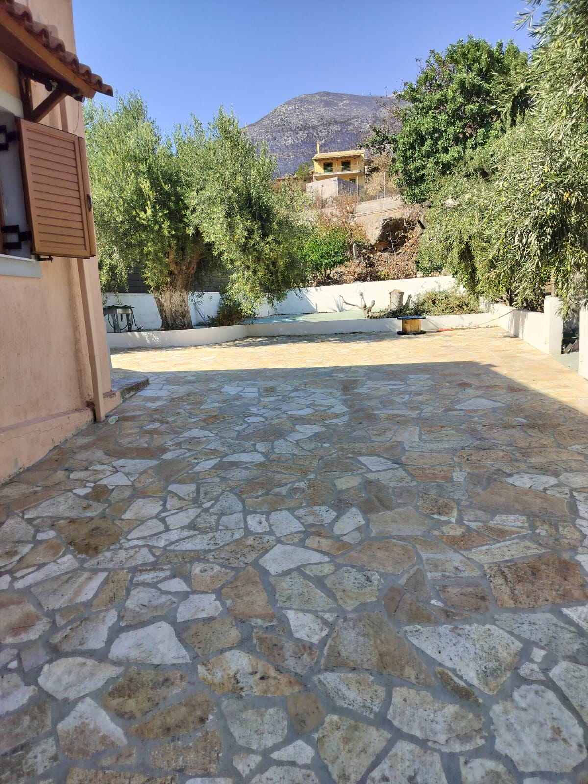Stone-paved courtyard and private parking at Porto Germeno Hotel