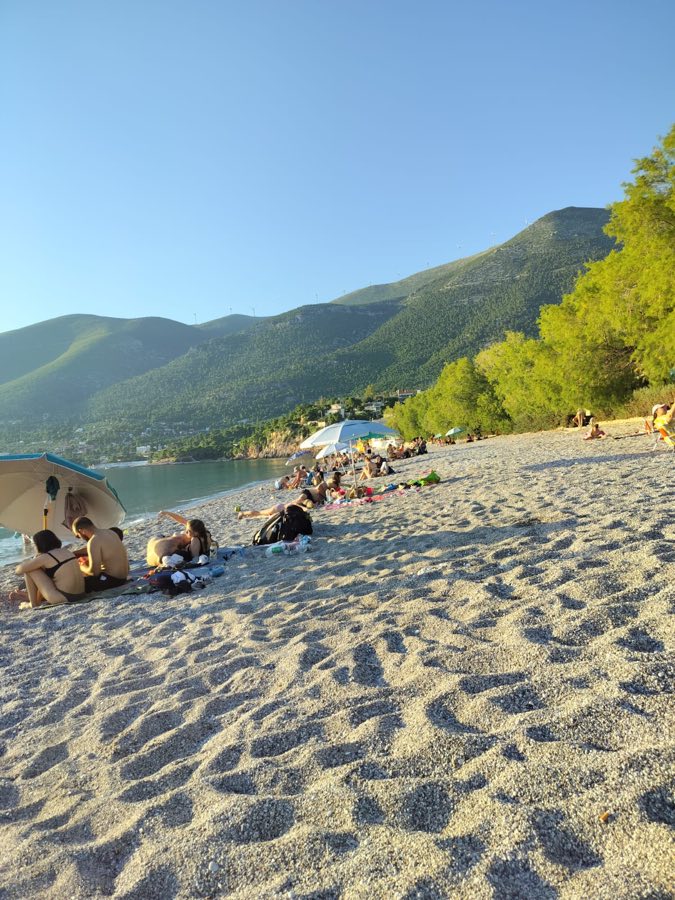 Sunbathers on the sandy village beach at Porto Germeno in summer